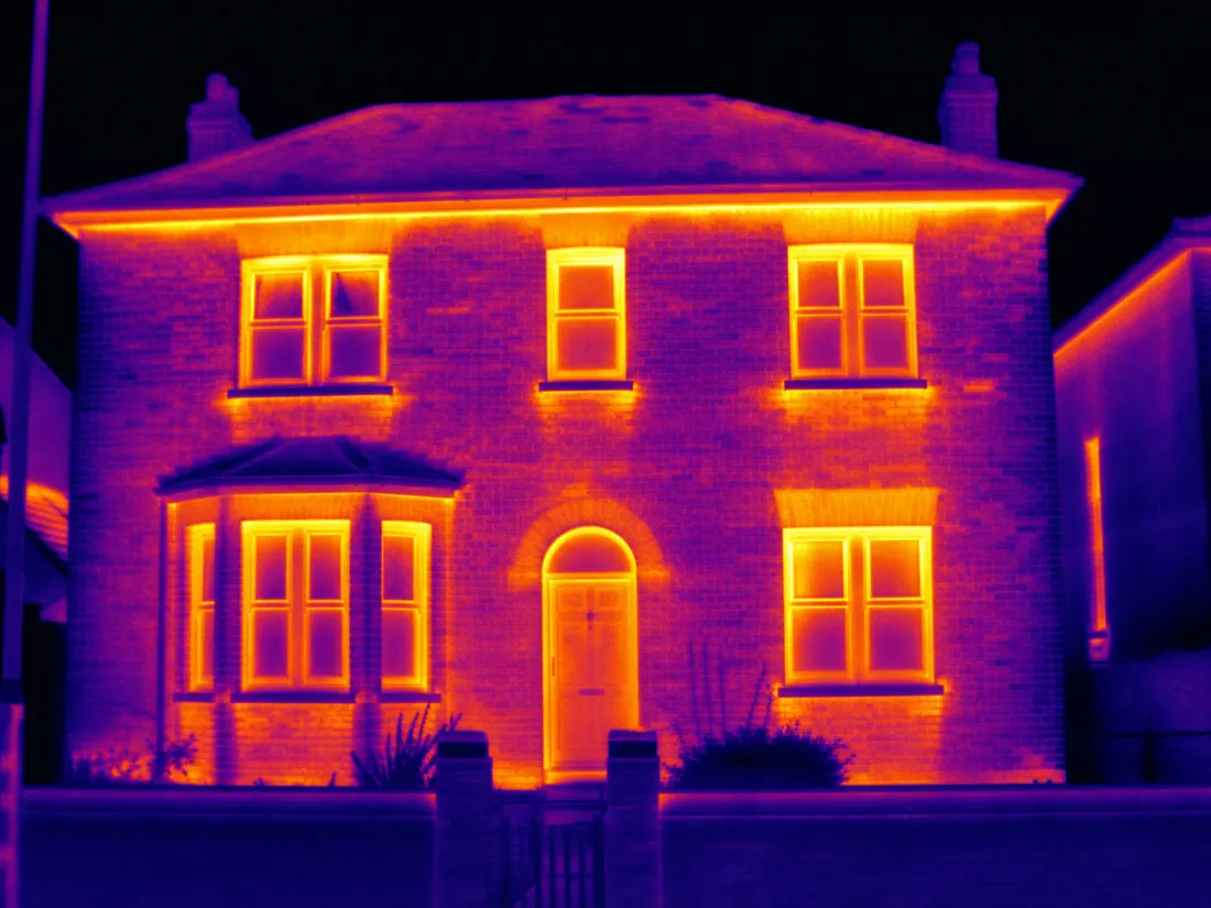 Thermal imaging view of a British house showing heat loss through windows and walls